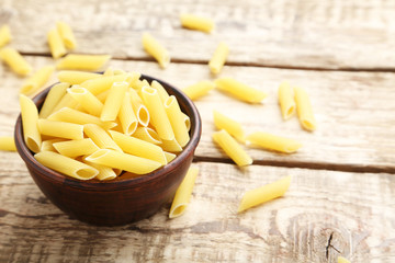 Pasta penne on the brown wooden table