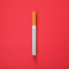 one cigarette on a red background