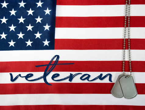 word veteran and military dog tags on American flag