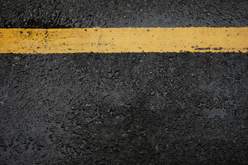 Fototapeta premium rough black asphalt road and yellow traffic lines ,this image for texture and transport