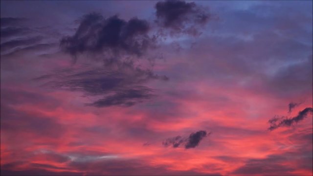 Clouds with orange, purple and black colors at sunset sky.