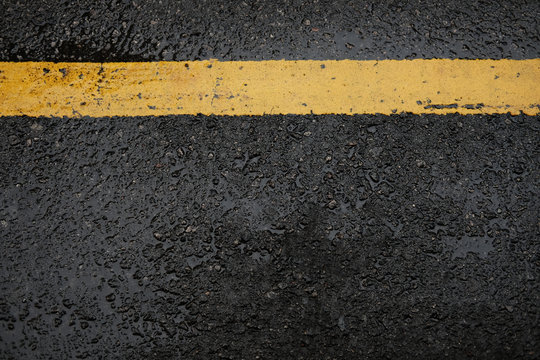 rough black asphalt road and yellow traffic lines ,this image for texture and transport