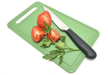 Помидоры и нож на разделочной доске