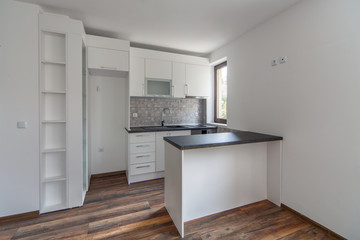 Fototapeta na wymiar New modern and empty white kitchen. New home. Interior photography. Wooden floor.