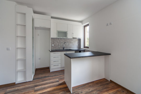 New modern and empty white kitchen. New home. Interior photography. Wooden floor.