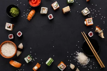 Zelfklevend Fotobehang Sushi and rolls background, frame on black, top view. © Prostock-studio