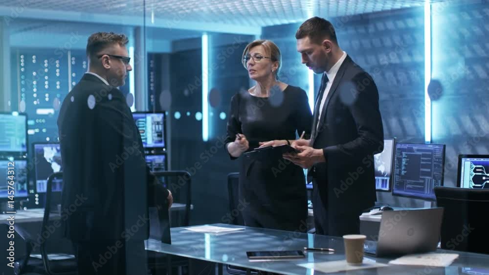 Leinwandbilder Three Corporate Managers Working at the Table in Monitoring Room. Room is Full of State of the Art Technology. Computers with Animated Screens. Shot on RED EPIC-W 8K Helium Cinema Camera.