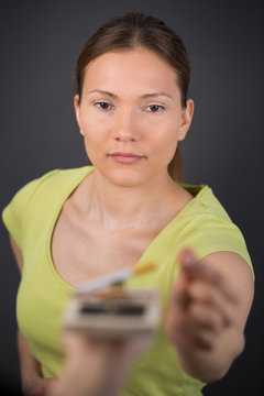 woman reaching for cigarette in a mousetrap