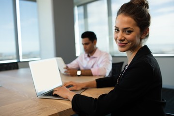 Businesswoman typing on laptop at table 