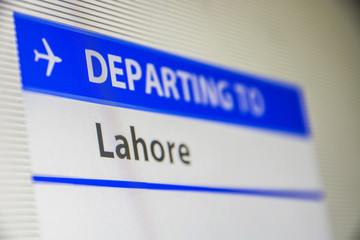 Computer screen close-up of status of flight departing to Lahore, Pakistan