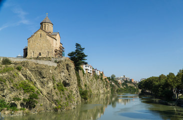 Fototapeta na wymiar View of the Metekhis Cathedral above Kura river in Tbilisi city center, Georgia