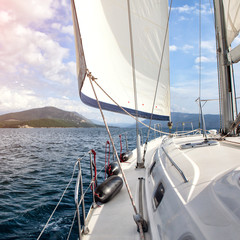 Obraz premium Front part of a sailboat, set on full sails to the sea