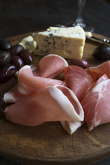 red wine, cheese, olives and ham on rustic weathered wood. The view from the top.