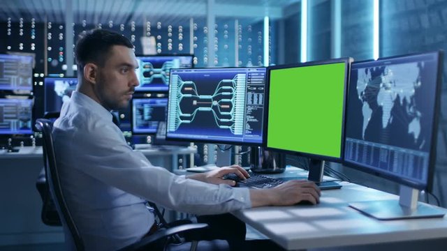Technical Controller/ Operator Working at His Workstation with Multiple Displays (Green Screen Mock-up). Possible Power Plant/ Airport Dispatcher/ Dam Worker/ Government Surveillance/ Space Program.
