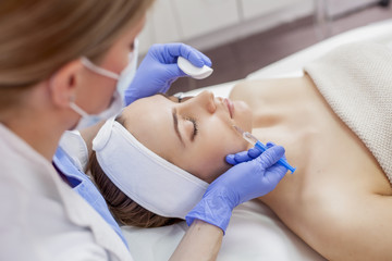 Naklejka premium Young beautiful woman in the beauty salon on the face treatment
