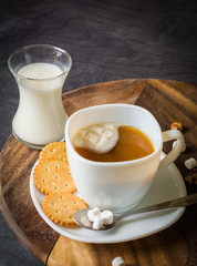 Morning coffee with marshmallows, cookies and milk. Dark wooden background.