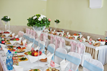 Vase with flowers at wedding tables set.