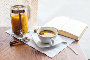 Cup and glass teapot with spicy fruit tea with orange
