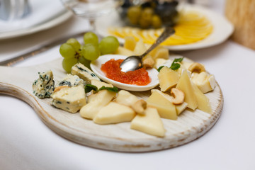 Wooden dish with snacks stands on box on dinner table Buffet table on wooden stands