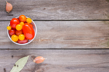 Merinated cherry tomatoes and saurkraut in a glass jar on a wooden table. Pickled vegetables