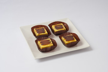 Mini caramel cheesecakes on square white plate