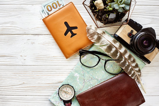 time to travel concept, flat lay. map passport money compass and glasses photo camera on white wooden background top view. planning vacation. space for text, wanderlust and explore.