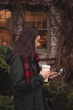 Side view of woman listening music on mobile