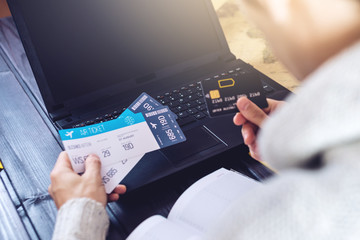 Fototapeta premium Man holding credit card and buys plane tickets on Internet