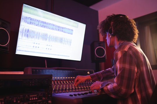 Male audio engineer using sound mixer