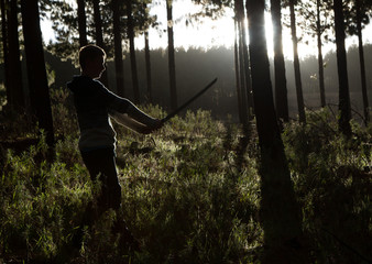 Boy with sword in forest - early morning