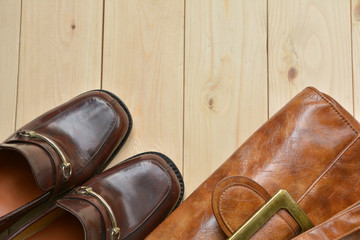 Male leather shoes with leather bag on wooden background