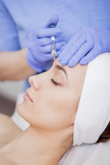 Young beautiful woman in the beauty salon on the face treatment
