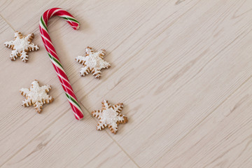 Gingerbread snowflake and lollipop on wood background. Aerial view. Copy space.