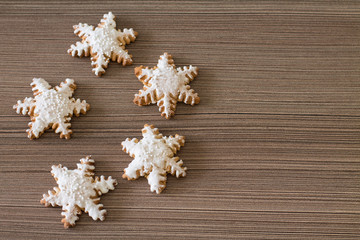 Gingerbread snowflake on wood background. Aerial view. Copy space.