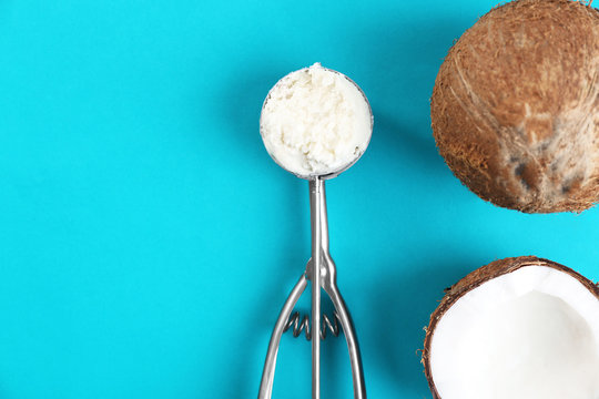 Coconuts and scoop with fresh ice cream on blue background