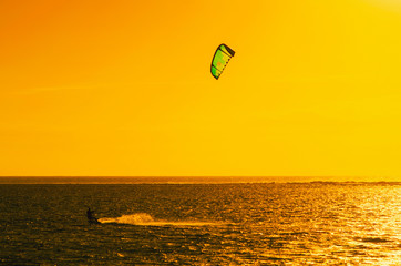 Professional kiter makes the difficult trick on a beautiful background of sunset, Mauritius
