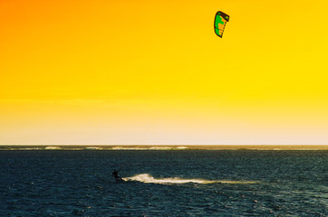 Professional kiter makes the difficult trick on a beautiful background of sunset, Mauritius