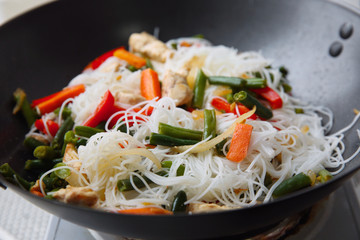 Delicious rice noodle stewing with vegetables on wok
