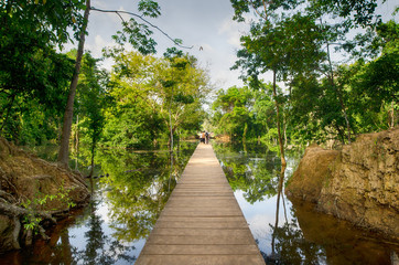 The wooden path towards to Neak Pean temple on artificial island. Angkor.