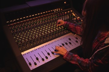 Female audio engineer using sound mixer