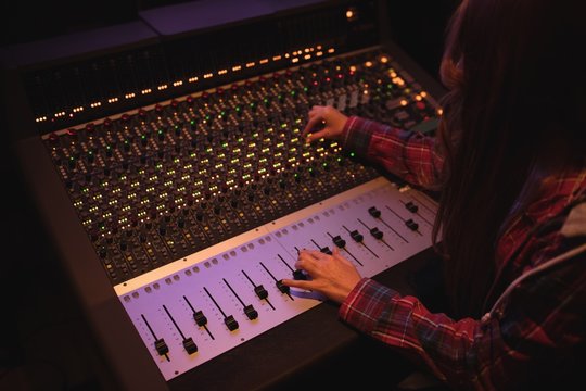 Female audio engineer using sound mixer
