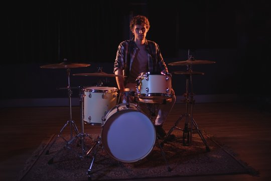 Portrait of drummer sitting with drum set