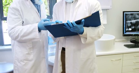 Attentive dentists discussing reports