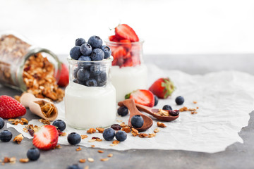 Delicious plain yogurt with fresh blueberry and strawberry in a glass jars