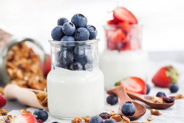 Delicious plain yogurt with fresh blueberry and strawberry in a glass jars
