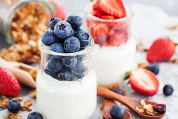 Delicious plain yogurt with fresh blueberry and strawberry in a glass jars