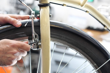 Serwis rowerowy. Mężczyzna  wymienia klocki hamulcowe w rowerze - obrazy, fototapety, plakaty