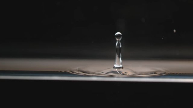 Drop of liquid causes ripples, slow motion