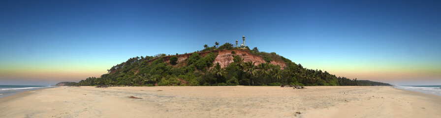 panoramic view of red colored stones cliff with mosque on top in Varkala, Kerala, India 