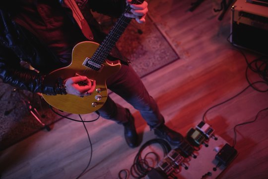 Guitarist playing electric guitar in recording studio